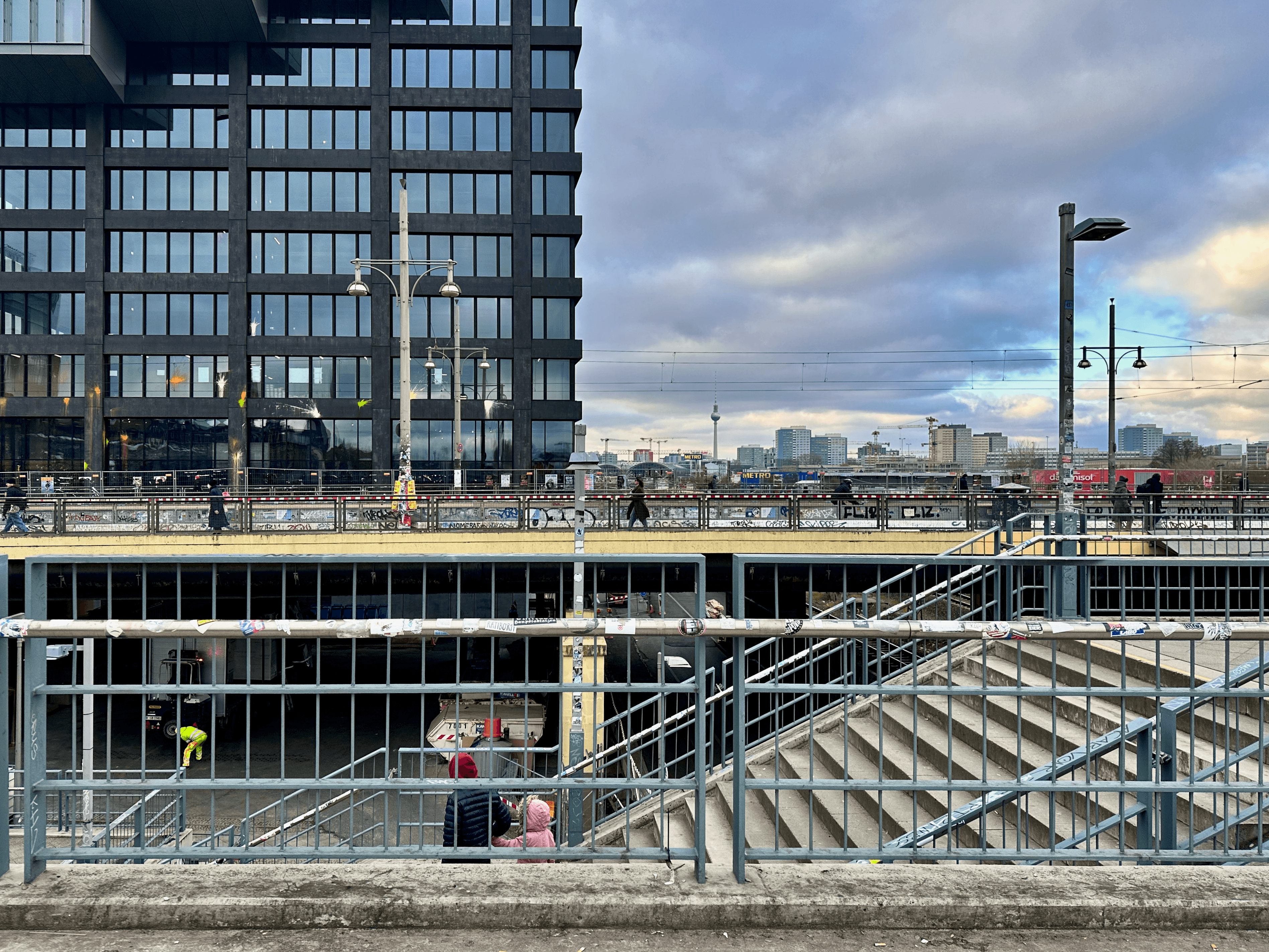 Scene in Berlin of Warschauer Straße with stairs, people, and buildings
