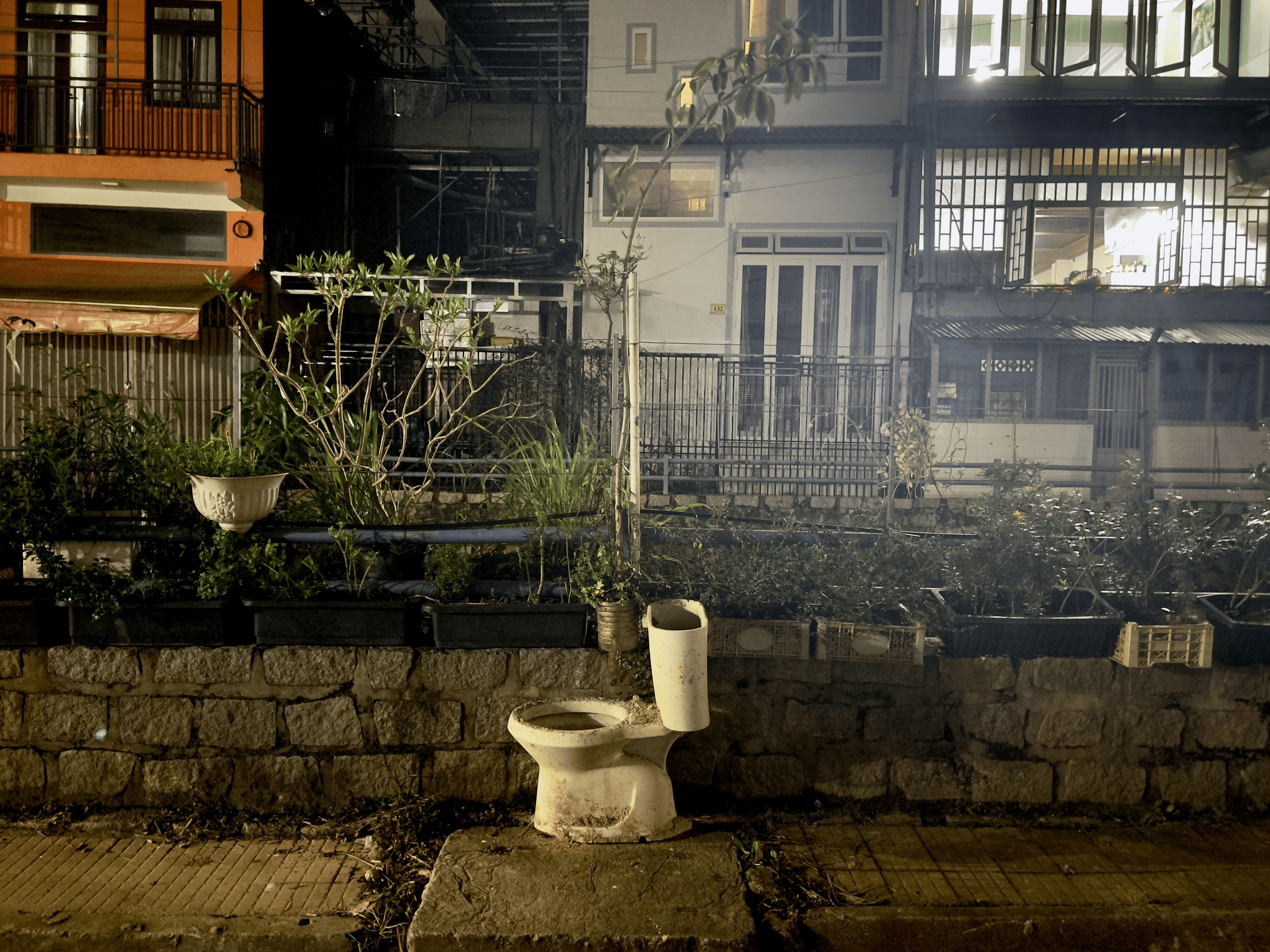 Discarded toilet and buildings along a canal in Da Lat, Vietnam