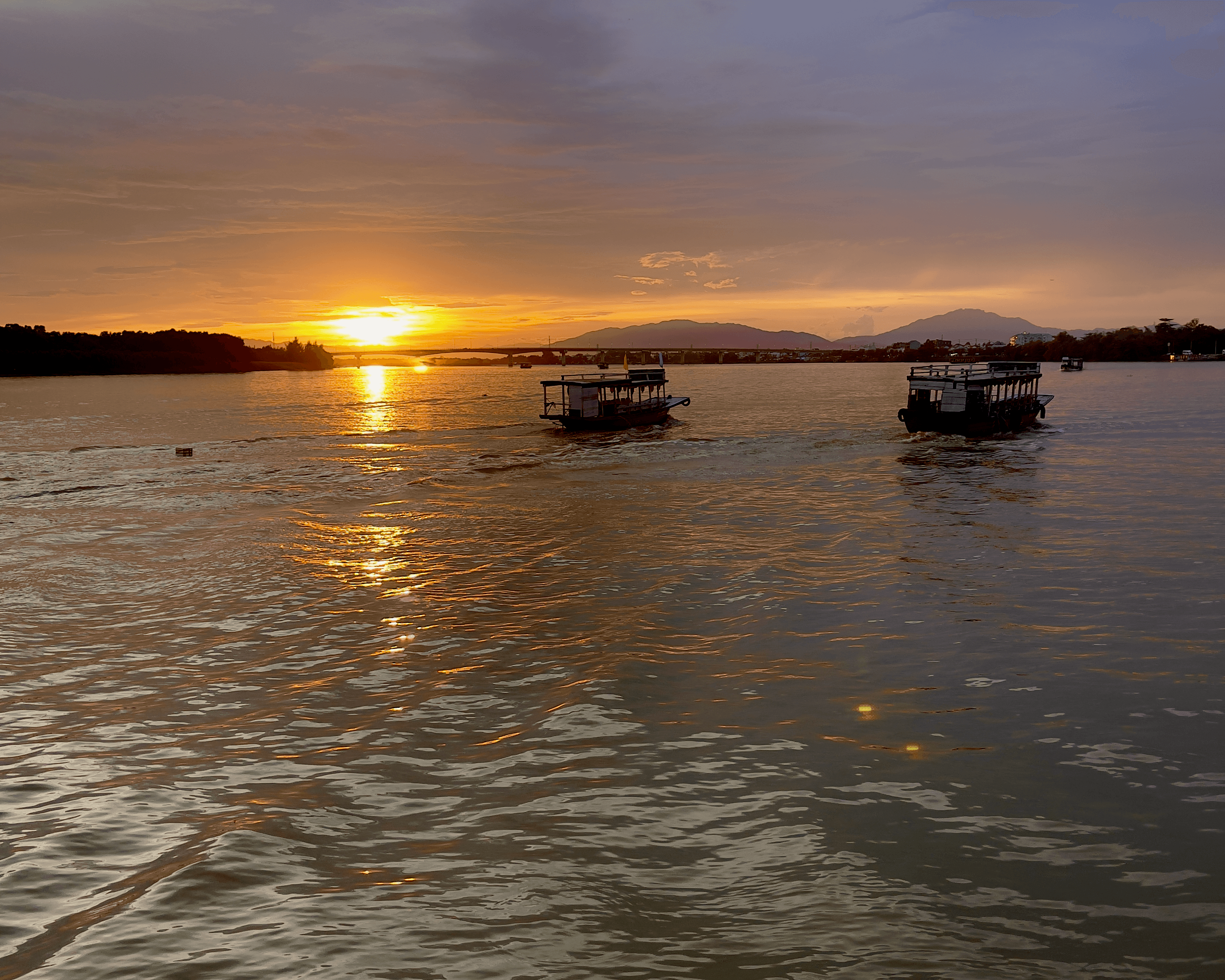 Sunset over a bridge and boats in Hoi An, Vietnam