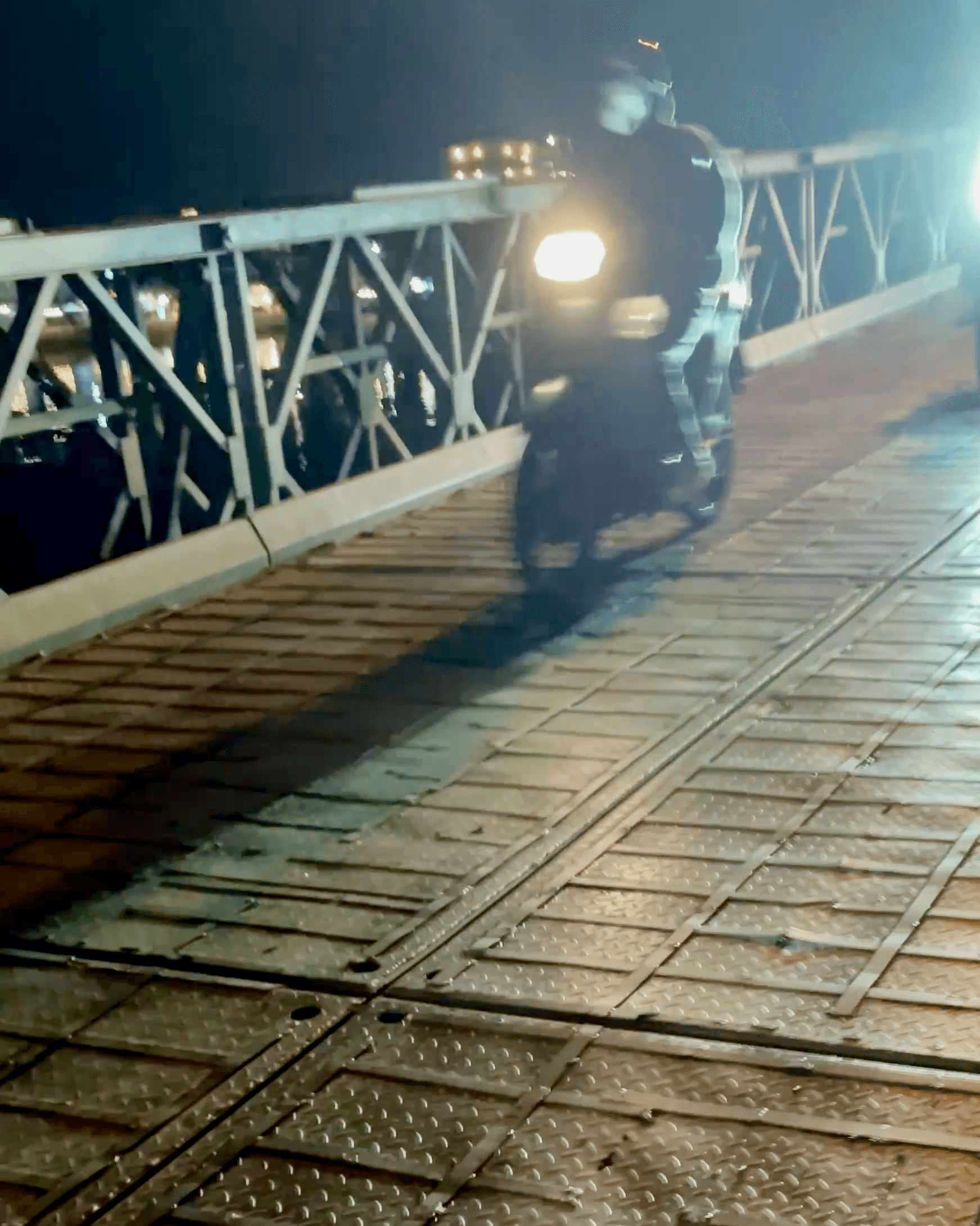 Bridge over a river in Hoi An, Vietnam with motorbikes and people
