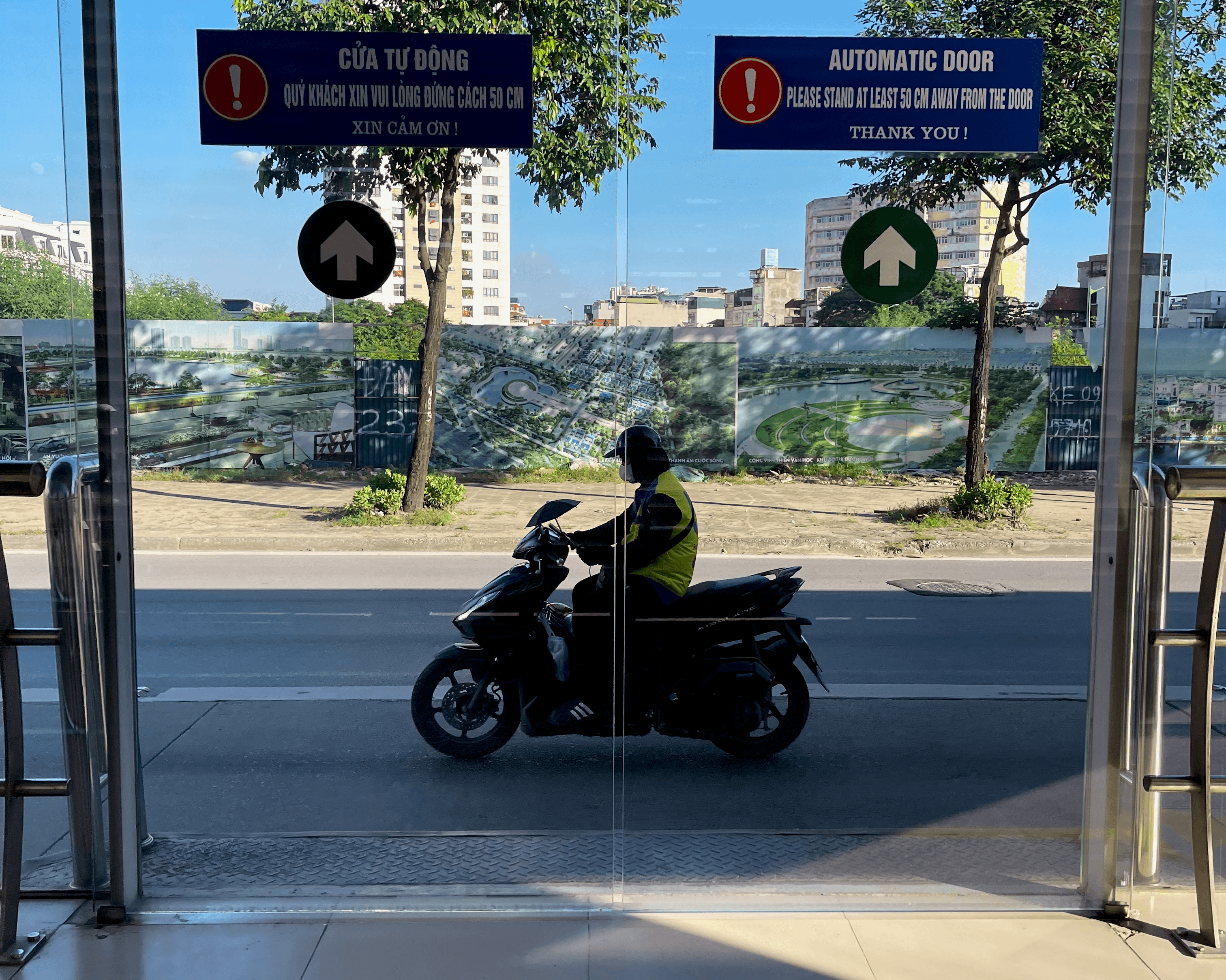 Moped driving by from inside a Hanoi bus station stop
