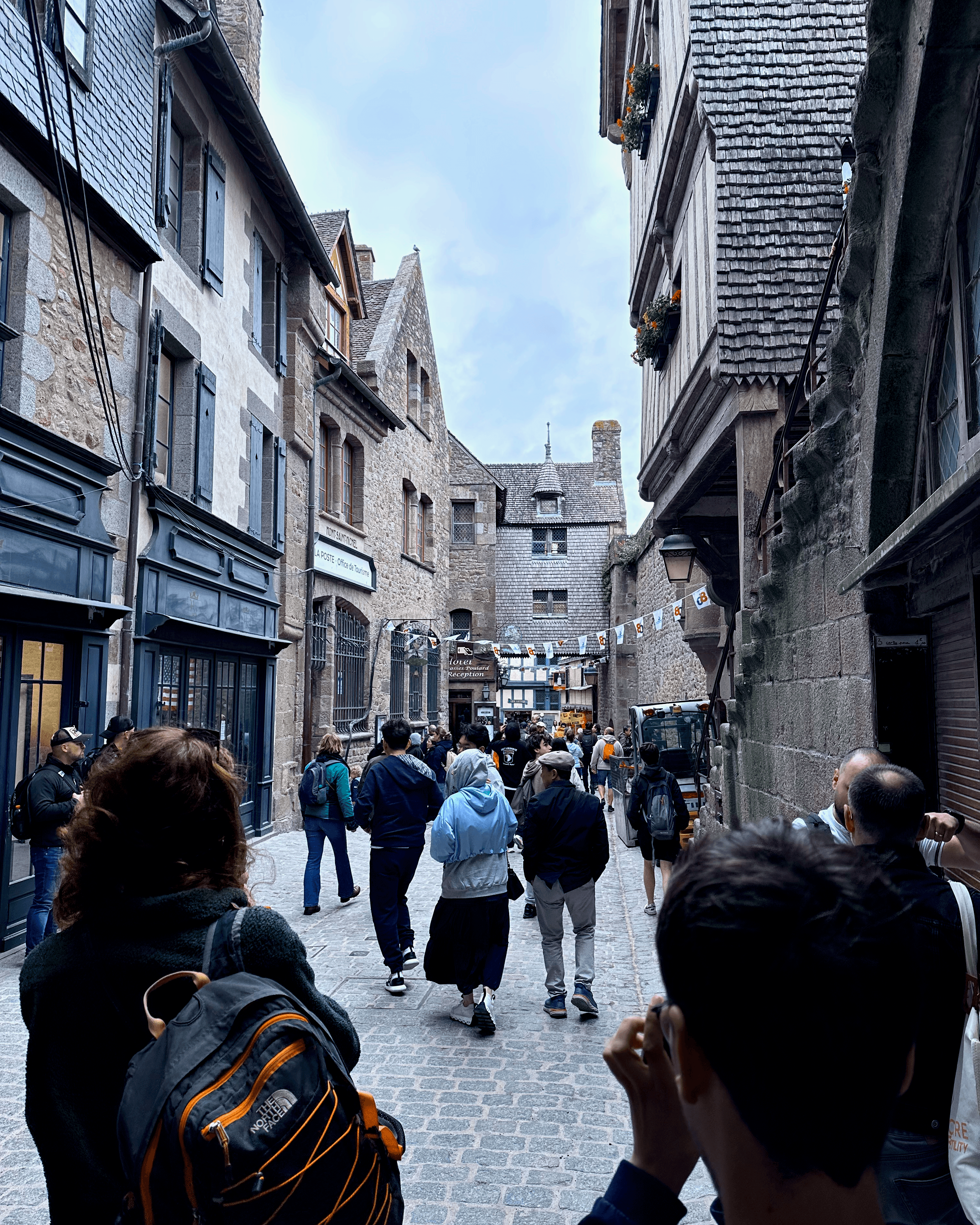 Cobblestone road, buildings, and people leading up to the abbey