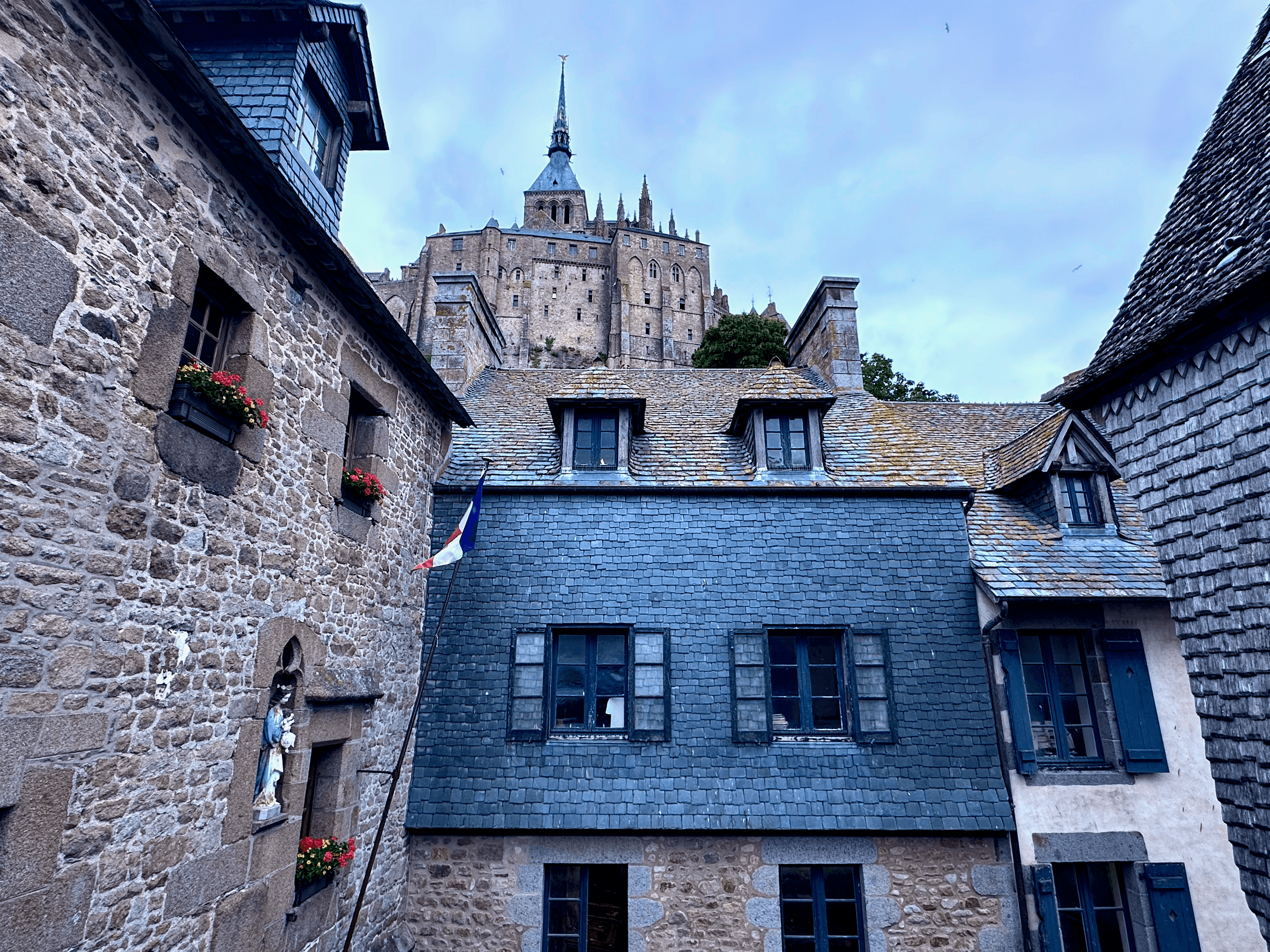 Mont Saint-Michel towering behind stone and shingled buildings on the island