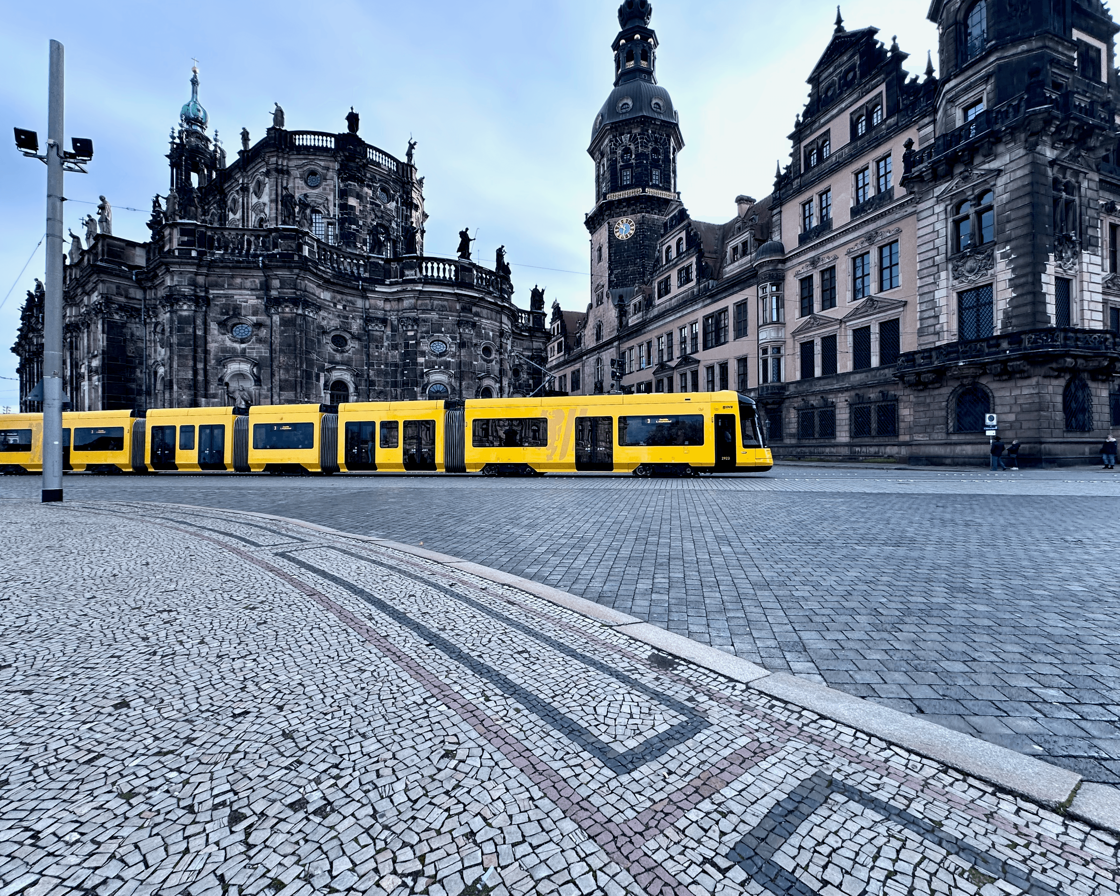 Yellow tram on a street in Dresden, Germany with old architecture and cobblestone