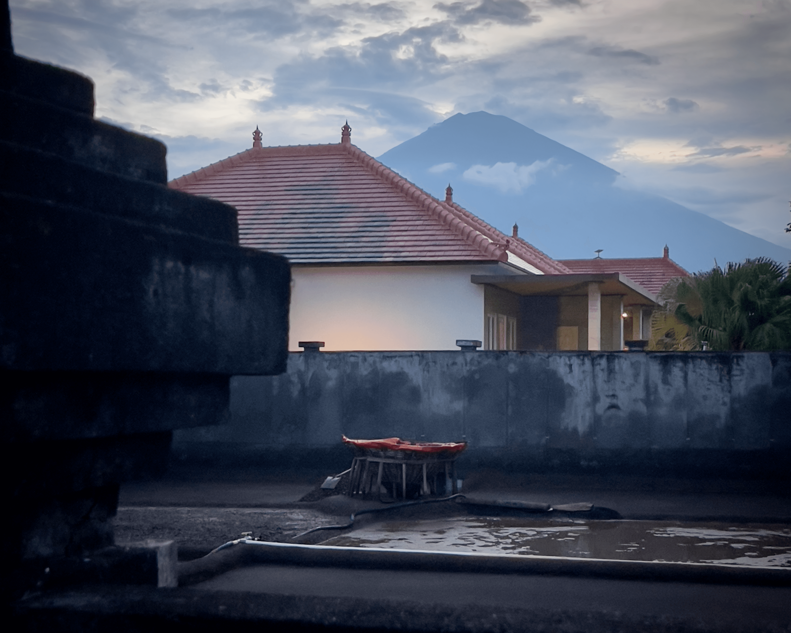 Mount Agung in the distance with rooftops and walls in Bali, Indonesia