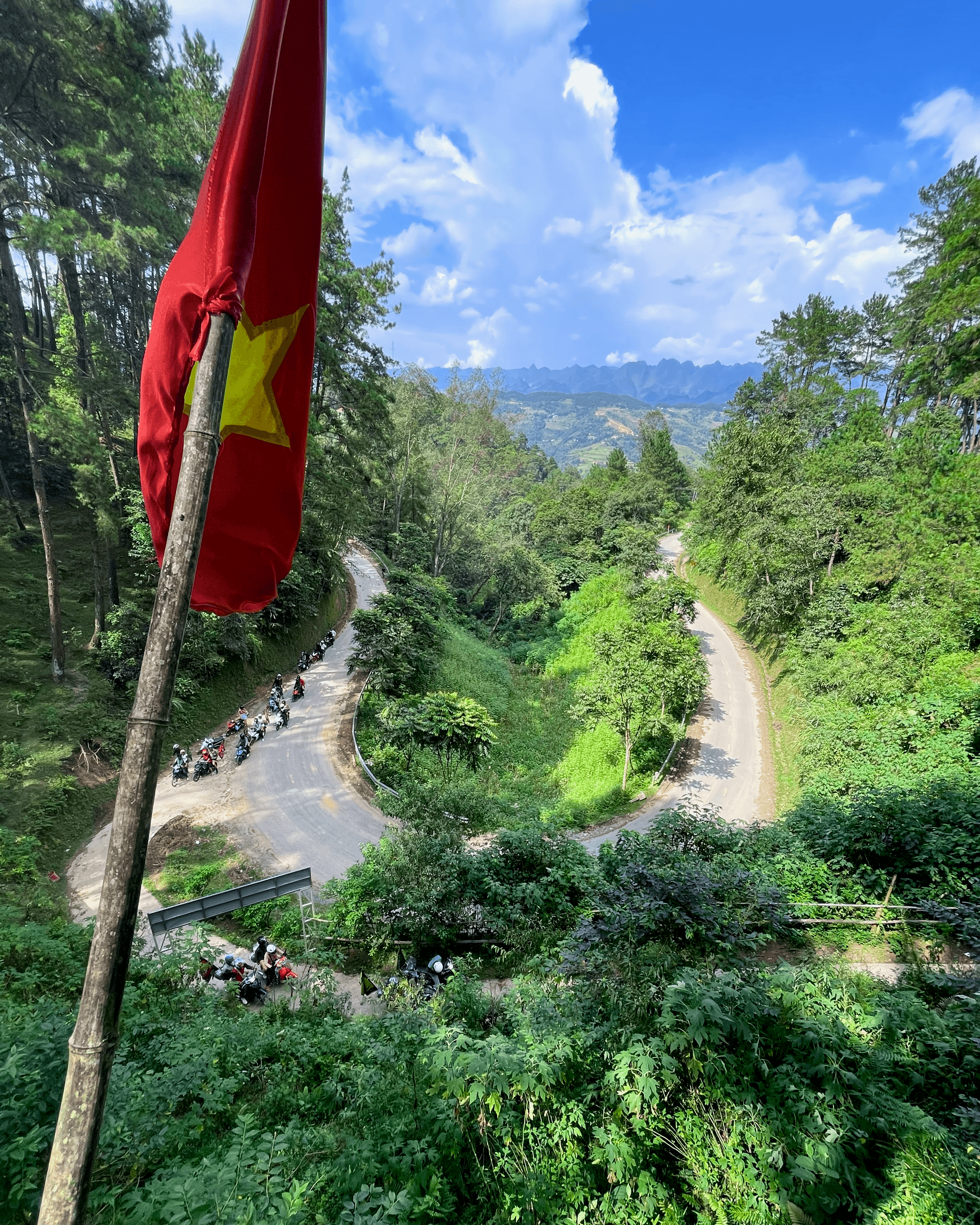 Vietnamese flag and motorbikes on a mountain road in Ha Giang, Vietnam