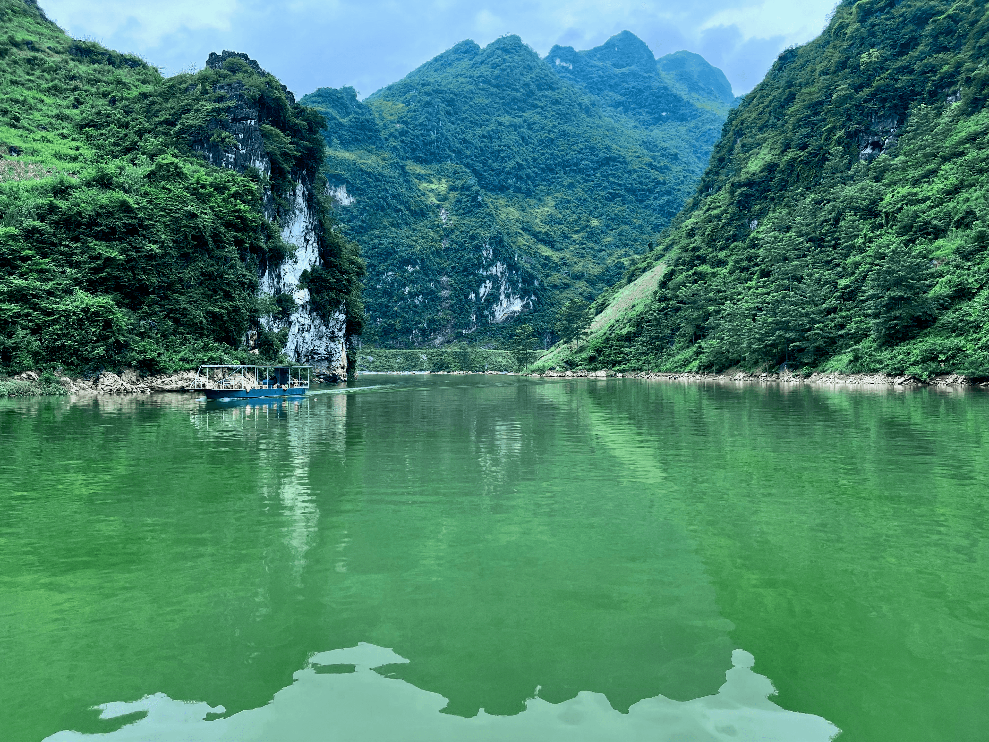 Mountains and boat seen from a river in Ha Giang, Vietnam