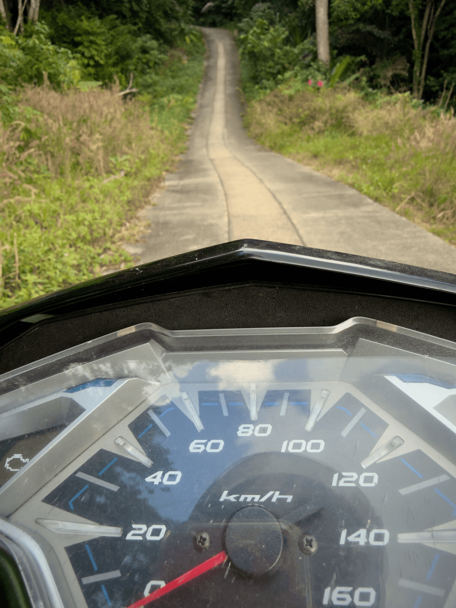 Motorbike and paved road leaving Grandfather Rock on Koh Tao, Thailand